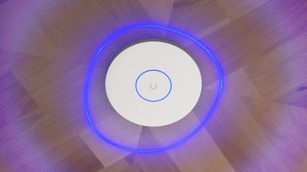 Access point WiFi profesional UniFi instalado en el techo con anillo de luz azul