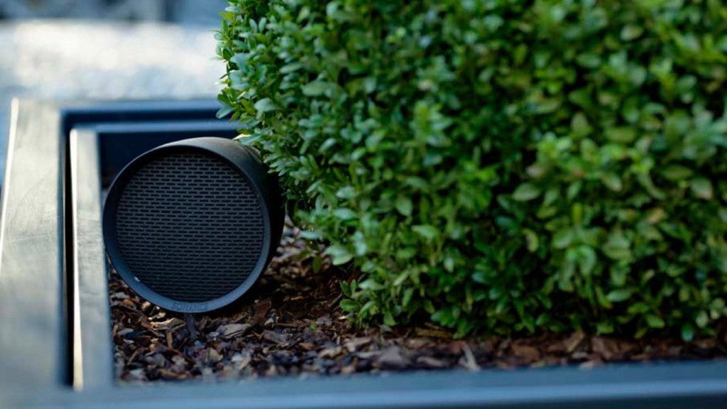Jardín exterior con bocinas de paisaje discretas entre las plantas para audio de terraza y piscina